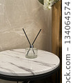Clear reed diffuser on round marble side table 134064574