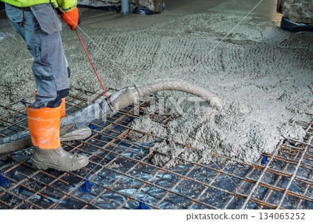 Concrete Pouring on Construction Site with Worker Leveling and Reinforcement Grid Concrete Pouring on Construction Site with Worker Leveling and Reinforcement Grid 134065252