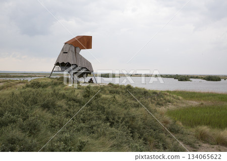 Observation tower Steltloper at Marker Wadden offers views of nature and water in the Netherlands on a cloudy day Observation tower Steltloper at Marker Wadden offers views of nature and water in the Netherlands on a cloudy day 134065622