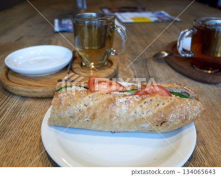 aromatic herbed bread accompanied by fresh tomatoes and leafy greens on charming white dish aromatic herbed bread accompanied by fresh tomatoes and leafy greens on charming white dish 134065643