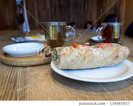 relaxed afternoon shared meal ambiance, intimate dining experience with bread and warm drinks 134065657