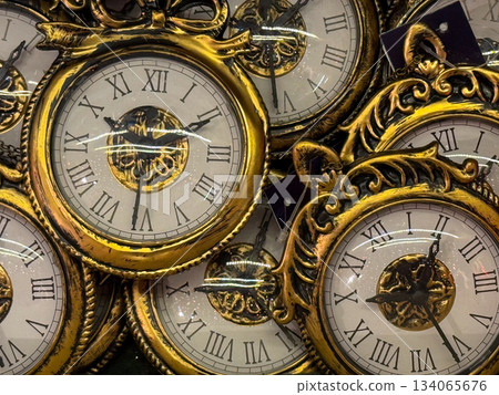 Golden vintage-style clock ornaments stacked in festive display. New Year symbolism, countdown moment, nostalgic Christmas decor and elegant holiday tradition mood 134065676