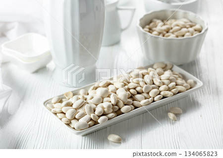 Dried white beans on a white table. 134065823