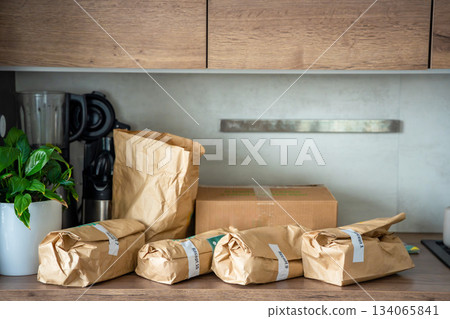 Meal kit ingredients sorted by recipe and placed on the kitchen counter. Concept of convenient grocery delivery for home cooking with pre-portioned ingredients. Meal kit ingredients sorted by recipe and placed on the kitchen counter. Concept of convenient grocery delivery for home cooking with pre-portioned ingredients. 134065841