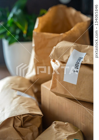 Close-up of brown paper bags with meal kits labeled Recept or Recipe. Subscription-based food delivery sorted by recipes. 134065846