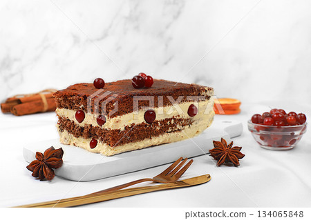 Homemade winter dessert, stollen or strudel with sweet cream filling, nuts, cinnamon, cranberries and poppy seeds. The concept of festive pastries, seasonal treats and cafe advertisements, 134065848