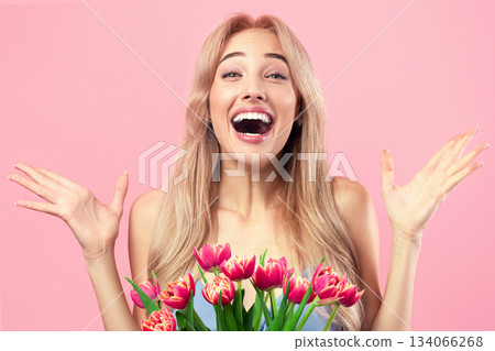 Beautiful millennial blonde feeling excited to receive lovely flower bouquet for spring holiday, pink studio background. Romantic lady celebrating birthday, Woman's Day, special occassion Beautiful millennial blonde feeling excited to receive lovely flower bouquet for spring holiday, pink studio background. Romantic lady celebrating birthday, Woman's Day, special occassion 134066268