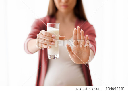 Unrecognizable Pregnant Woman Holding Glass Of Milk And Showing Stop Gesture With Open Palm At Camera, Expectant Lady Having Lactose Intollerance, Cropped Shot With Selective Focus, Copy Space 134066361
