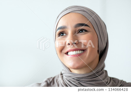 Joyful young arab woman in hijab smiling and looking at copy space, closeup portrait, panorama. Muslim lady posing in office. Gender equality, working opportunities for women in islam concept 134066428