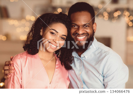Happy Loving Family. Portrait of beautiful young african american couple in love posing and looking at camera. Smiling black bearded man embracing and hugging his pretty woman. Healthy Relationship 134066476