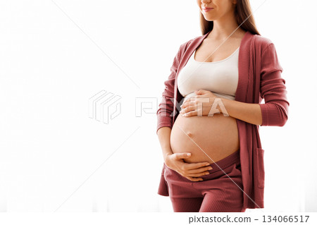 Maternity Concept. Portrait Of Young Beautiful Pregnant Lady Standing Near Window At Home, Dreamy Expectant Woman Tenderly Embracing Her Naked Belly And Smiling, Enjoying Prenatal Time, Copy Space Maternity Concept. Portrait Of Young Beautiful Pregnant Lady Standing Near Window At Home, Dreamy Expectant Woman Tenderly Embracing Her Naked Belly And Smiling, Enjoying Prenatal Time, Copy Space 134066517
