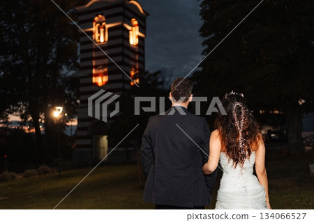 Wedding couple walking towards church at night 134066527