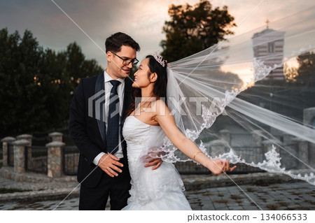 Interracial wedding couple embracing at sunset 134066533