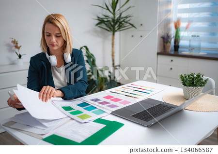 Woman freelancer designing color palette working from home office Woman freelancer designing color palette working from home office 134066587