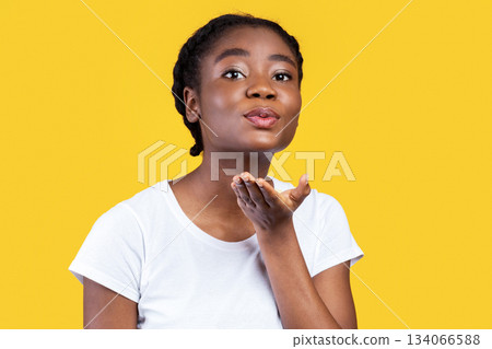 Pretty Black Woman Blowing A Kiss To Camera Posing On Yellow Studio Background. Flirt And Romance Concept. African Young Lady Flirting And Sending Air Kisses, Advertisement Banner Pretty Black Woman Blowing A Kiss To Camera Posing On Yellow Studio Background. Flirt And Romance Concept. African Young Lady Flirting And Sending Air Kisses, Advertisement Banner 134066588
