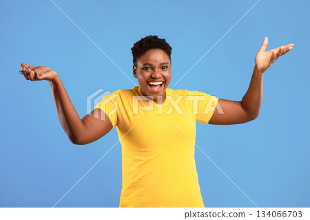 Come On. Joyful African American Plus-Size Woman Gesturing With Raised Hands Urging To Stand Up Standing Posing Over Blue Studio Background, Smiling To Camera. Come On. Joyful African American Plus-Size Woman Gesturing With Raised Hands Urging To Stand Up Standing Posing Over Blue Studio Background, Smiling To Camera. 134066703