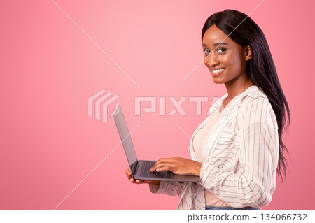 Young African American woman with laptop talking to family or friends, conducting business meeting, teaching online on pink studio background. Concept of distance work, education or communication Young African American woman with laptop talking to family or friends, conducting business meeting, teaching online on pink studio background. Concept of distance work, education or communication 134066732