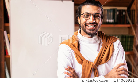 Online Distant Learning. Smiling Indian Teacher Guy Posing Near Blackboard With English Language Grammar Rules Standing At Home. Knowledge, Distance Teaching And Modern Education Concept. Copy Space 134066931