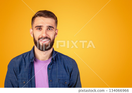 Carefree young guy looking at camera and smiling over orange studio background, panorama. Portrait of joyful bearded hipster man with happy face expression posing in casual outfit Carefree young guy looking at camera and smiling over orange studio background, panorama. Portrait of joyful bearded hipster man with happy face expression posing in casual outfit 134066966