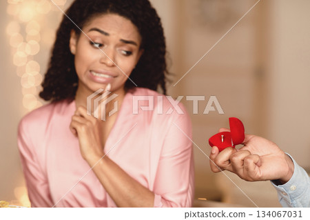 Relationship Breakup Concept. Black man making marriage proposal to young woman rejecting offer, frustrated girlfriend refuse to marry her boyfriend, not taking engagement ring, saying no, thinking Relationship Breakup Concept. Black man making marriage proposal to young woman rejecting offer, frustrated girlfriend refuse to marry her boyfriend, not taking engagement ring, saying no, thinking 134067031