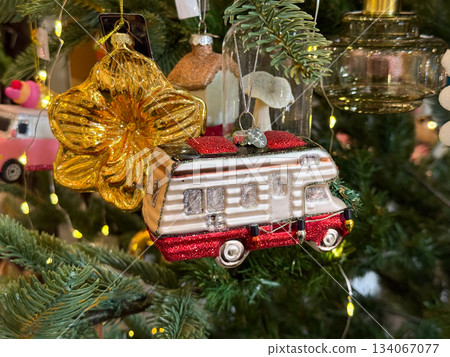 Camper van ornament hanging on Christmas tree symbolizing travel nostalgia and festive road-trip spirit Camper van ornament hanging on Christmas tree symbolizing travel nostalgia and festive road-trip spirit 134067077