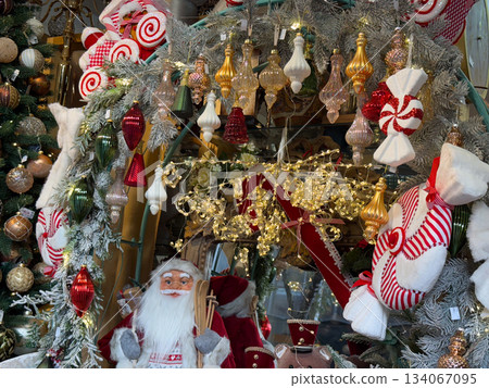 Christmas ornaments and golden lights in a festive winter shop display. Celebration, nostalgia, childhood magic, warm cozy holiday mood and decorative seasonal charm Christmas ornaments and golden lights in a festive winter shop display. Celebration, nostalgia, childhood magic, warm cozy holiday mood and decorative seasonal charm 134067095