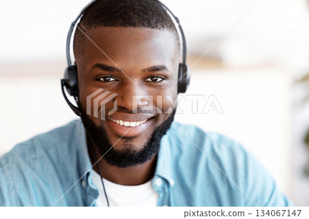 Hotline Support Service. Closeup Portrait Of Smiling African American Customer Service Operator In Headset, Friendly Black Call Center Manager In Headphones Looking At Camera, Free Space Hotline Support Service. Closeup Portrait Of Smiling African American Customer Service Operator In Headset, Friendly Black Call Center Manager In Headphones Looking At Camera, Free Space 134067147