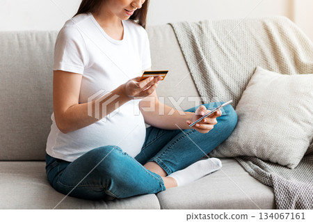 Millennial Pregnant Lady With Smartphone And Credit Card At Home Shopping Online While Relaxing On Sofa In Living Room, Happy Expectant Lady Enjoying Easy Payments And Purchasing In Internet 134067161
