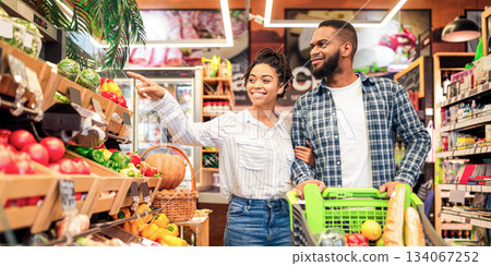 Black Family On Grocery Shopping In Supermarket. Happy African Couple Buying Organic Vegetabels And Fresh Fruits In Local Food Store Standing With Shop Cart. Customers Choosing Supplies Black Family On Grocery Shopping In Supermarket. Happy African Couple Buying Organic Vegetabels And Fresh Fruits In Local Food Store Standing With Shop Cart. Customers Choosing Supplies 134067252