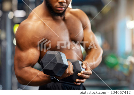 Sports equipment for gym concept. Cropped of black muscular bodybuilder exercising with barbell at modern gym, copy space. African american athletic man working out with dumbbell Sports equipment for gym concept. Cropped of black muscular bodybuilder exercising with barbell at modern gym, copy space. African american athletic man working out with dumbbell 134067412