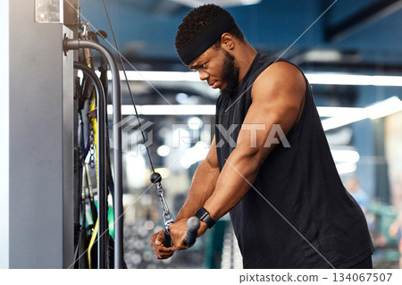 Muscular african american bodybuilder having workout at modern gym, using peck deck machine, copy space. Concentrated black sportsman training muscles on block exerciser in gym Muscular african american bodybuilder having workout at modern gym, using peck deck machine, copy space. Concentrated black sportsman training muscles on block exerciser in gym 134067507