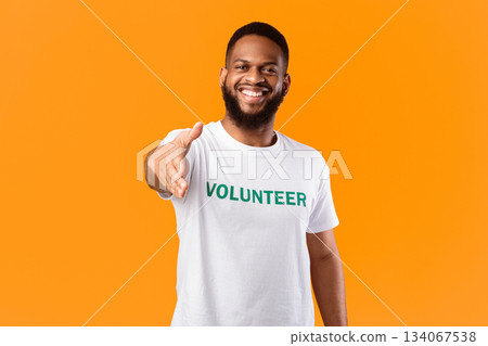 Cheerful Volunteer Guy Stretching Hand For Handshake Greeting To Camera Standing Posing In Studio Over Yellow Background. Voluntary Work, Join Our Volunteering Team Concept Cheerful Volunteer Guy Stretching Hand For Handshake Greeting To Camera Standing Posing In Studio Over Yellow Background. Voluntary Work, Join Our Volunteering Team Concept 134067538