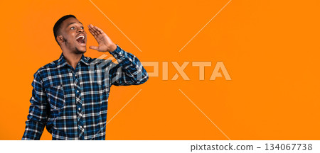 Hey, Attention. Positive Black Man Shouting Holding Hand Near Mouth Advertising Something Standing Over Yellow Studio Background. Panorama, Copy Space Hey, Attention. Positive Black Man Shouting Holding Hand Near Mouth Advertising Something Standing Over Yellow Studio Background. Panorama, Copy Space 134067738