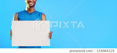 Sport Advertisement. Unrecognizable Athlete Holding Blank White Board Advertising Gym Over Blue Studio Background. Cropped, Mockup, Panorama Sport Advertisement. Unrecognizable Athlete Holding Blank White Board Advertising Gym Over Blue Studio Background. Cropped, Mockup, Panorama 134068129