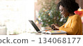 Happy afro girl freelancer using mobile phone, working with laptop in cafe, side view, copy space 134068177