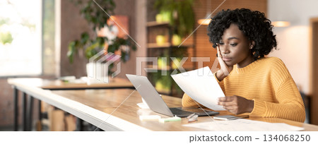 Concentrated afro girl professional editor working with text at cafe, using laptop, empty space Concentrated afro girl professional editor working with text at cafe, using laptop, empty space 134068250