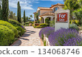 A stunning Mediterranean-style house is showcased with vibrant lavender plants lining the pathway under a clear blue sky. The inviting atmosphere highlights the propertys charm and appeal. A stunning Mediterranean-style house is showcased with vibrant lavender plants lining the pathway under a clear blue sky. The inviting atmosphere highlights the propertys charm and appeal. 134068746