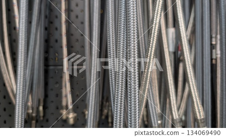 Reflective metallic coils neatly hung in industrial workspace Reflective metallic coils neatly hung in industrial workspace 134069490