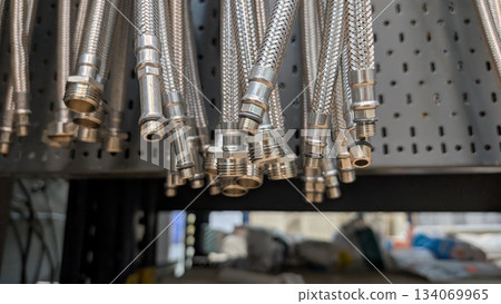 Metal Plumbing Hoses are elegantly Hanging in the Displays of a Local Hardware Store Metal Plumbing Hoses are elegantly Hanging in the Displays of a Local Hardware Store 134069965