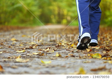 Woman walking cross country trail in autumn forest Woman walking cross country trail in autumn forest 134070050