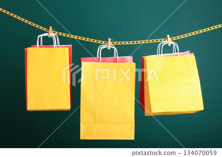 Shopping yellow gift bags on green background 134070059
