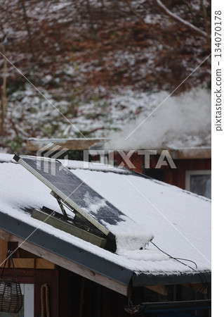Snow-covered solar panels on a rustic cabin roof Snow-covered solar panels on a rustic cabin roof 134070178
