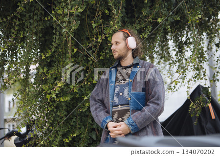 Individual adjusts sound equipment near grapevines in natural setting 134070202