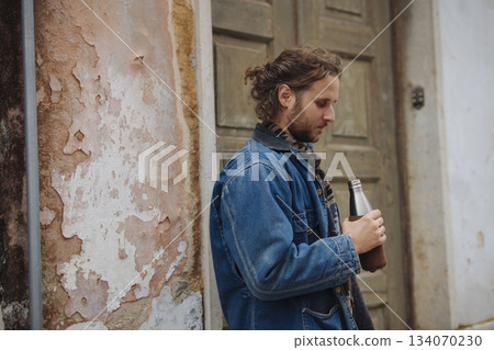 Casual scene of individual sipping near textured urban backdrops Casual scene of individual sipping near textured urban backdrops 134070230