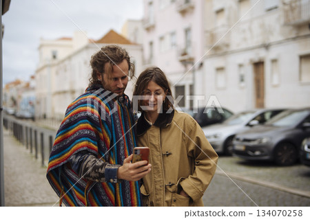 Pair of individuals enjoys viewing vacation snapshots nearby 134070258