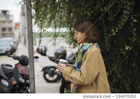 woman with coffee and phone by ivy, digital nomad break woman with coffee and phone by ivy, digital nomad break 134070261
