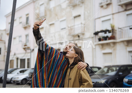 Cheerful travelers enjoy candid snapshot in lively urban environment 134070269