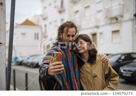 Unscripted image of partners in colorful bohemian attire outdoors 134070273