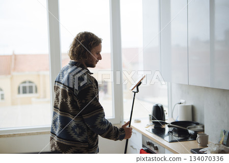 solo creator filming kitchen routine with selfie stick 134070336
