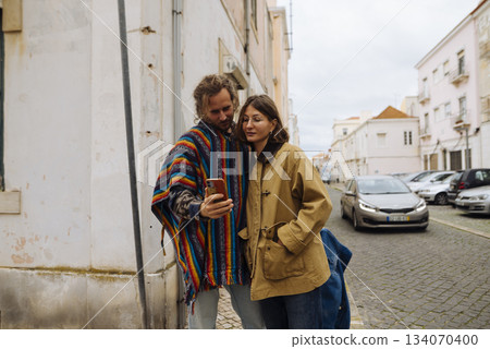 Two people sharing quiet pause near colorful architectural wall Two people sharing quiet pause near colorful architectural wall 134070400